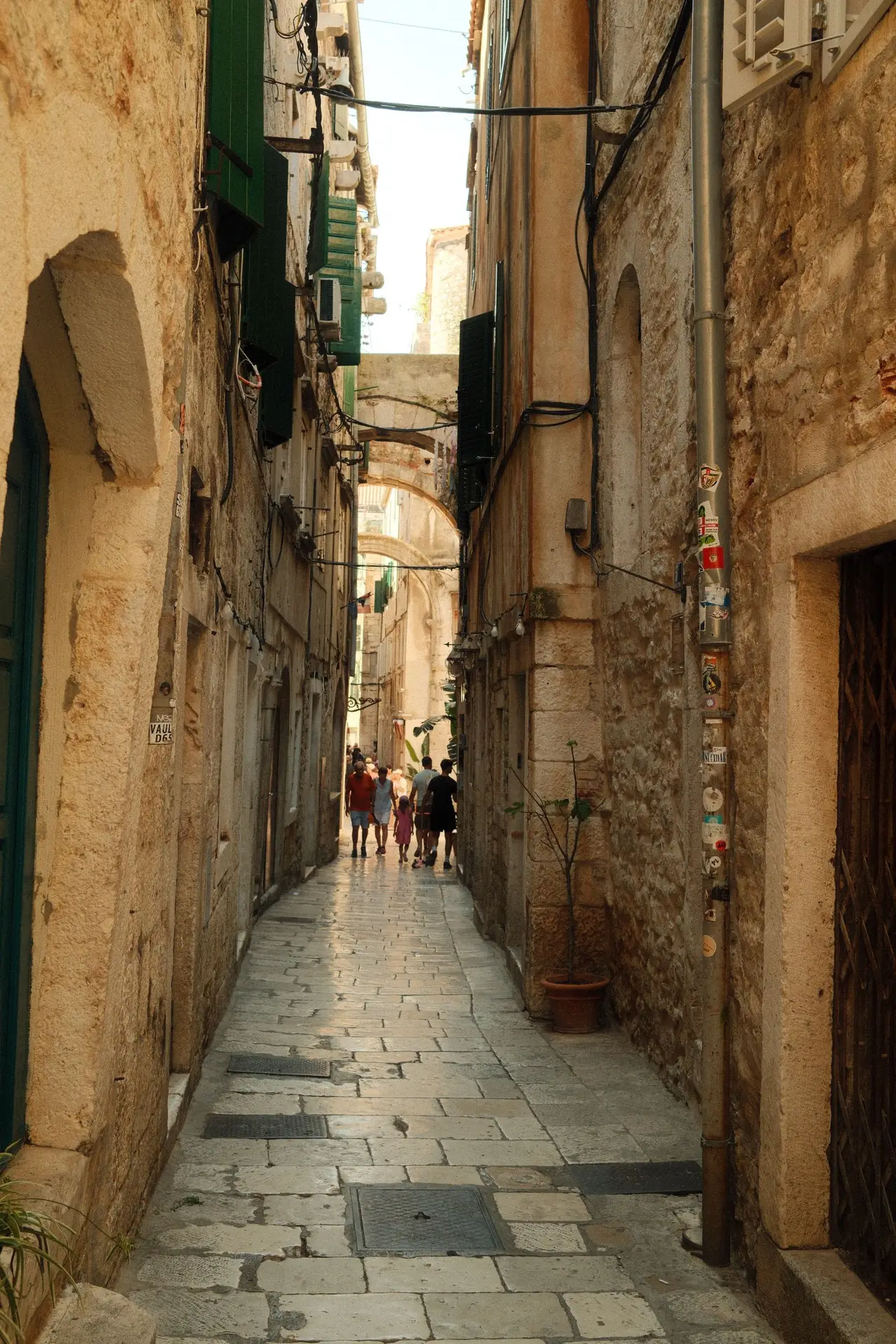 narrow stone street with green doors and windows