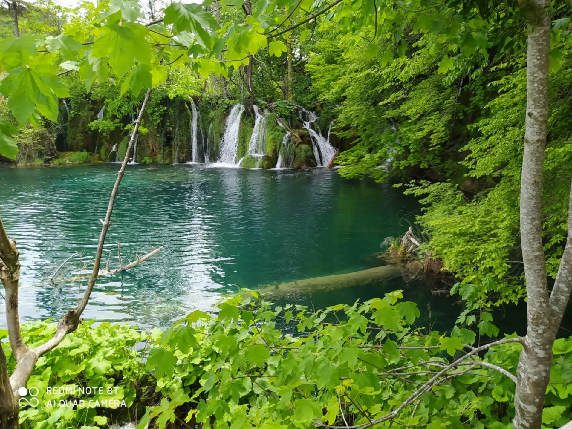 green lake with waterfall in nature